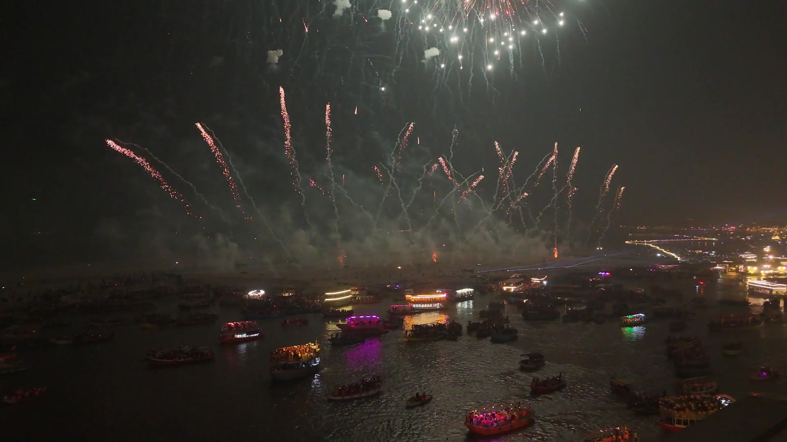 The Ganga at Dev Diwali, fireworks above a fleet of lit boats